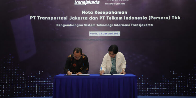 Proses penandatanganan nota kesepahaman kerja sama Telkom dan Transjakarta oleh PLT Direktur Enterprise and Business Service Telkom FM Venusiana R. (kanan) dan Direktur Utama Transjakarta M. Kuncoro Wibowo (kiri) pada Kamis (26/1). (Dok Telkom)