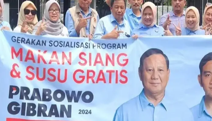 Banner Prabowo Gibran Program Makan Siang & Susu Gratis Dipegang Para Relawan